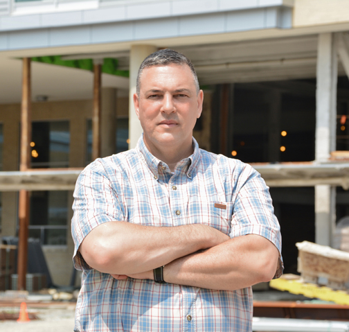 Photo of John in front of construction site